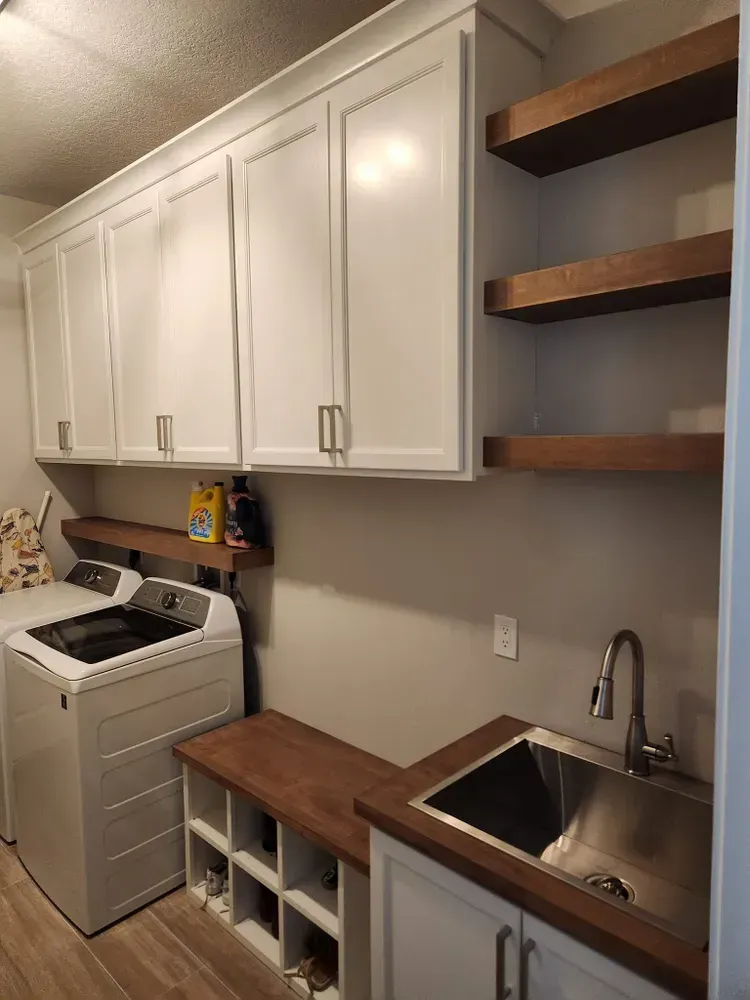A laundry room with a washer and dryer and a sink.