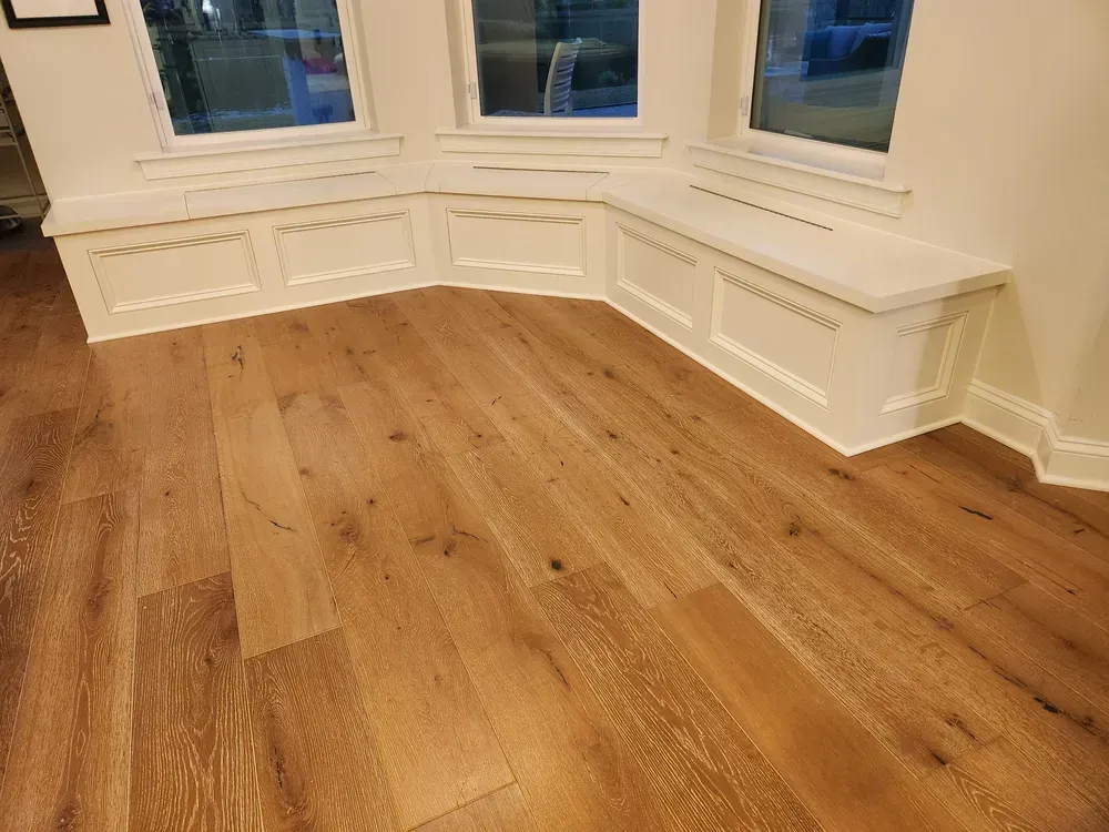 A living room with hardwood floors and a window seat.