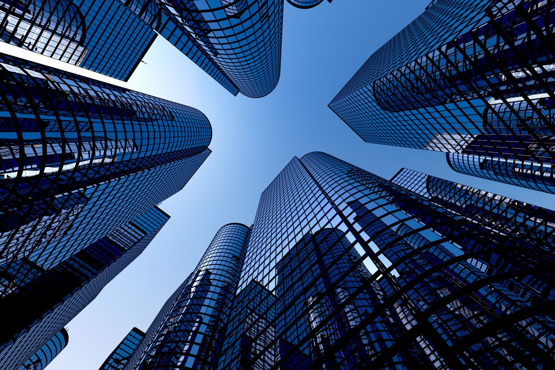 Looking up at a cluster of skyscrapers with a blue sky in the background