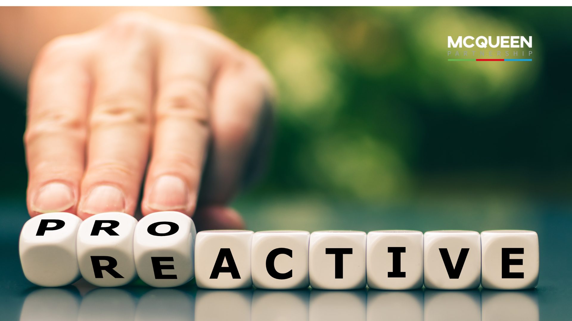 A person is holding dice that spell out the word proactive.