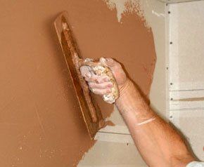 A plasterer plastering a wall