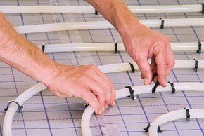 A plumber installing underfloor heating