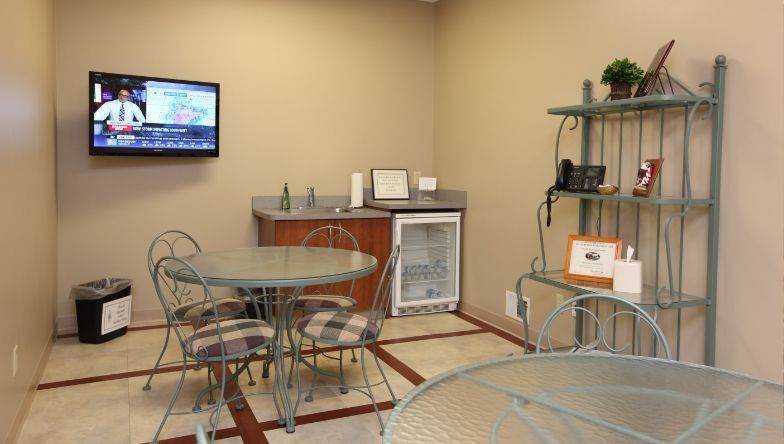 A room with a table and chairs and a flat screen tv