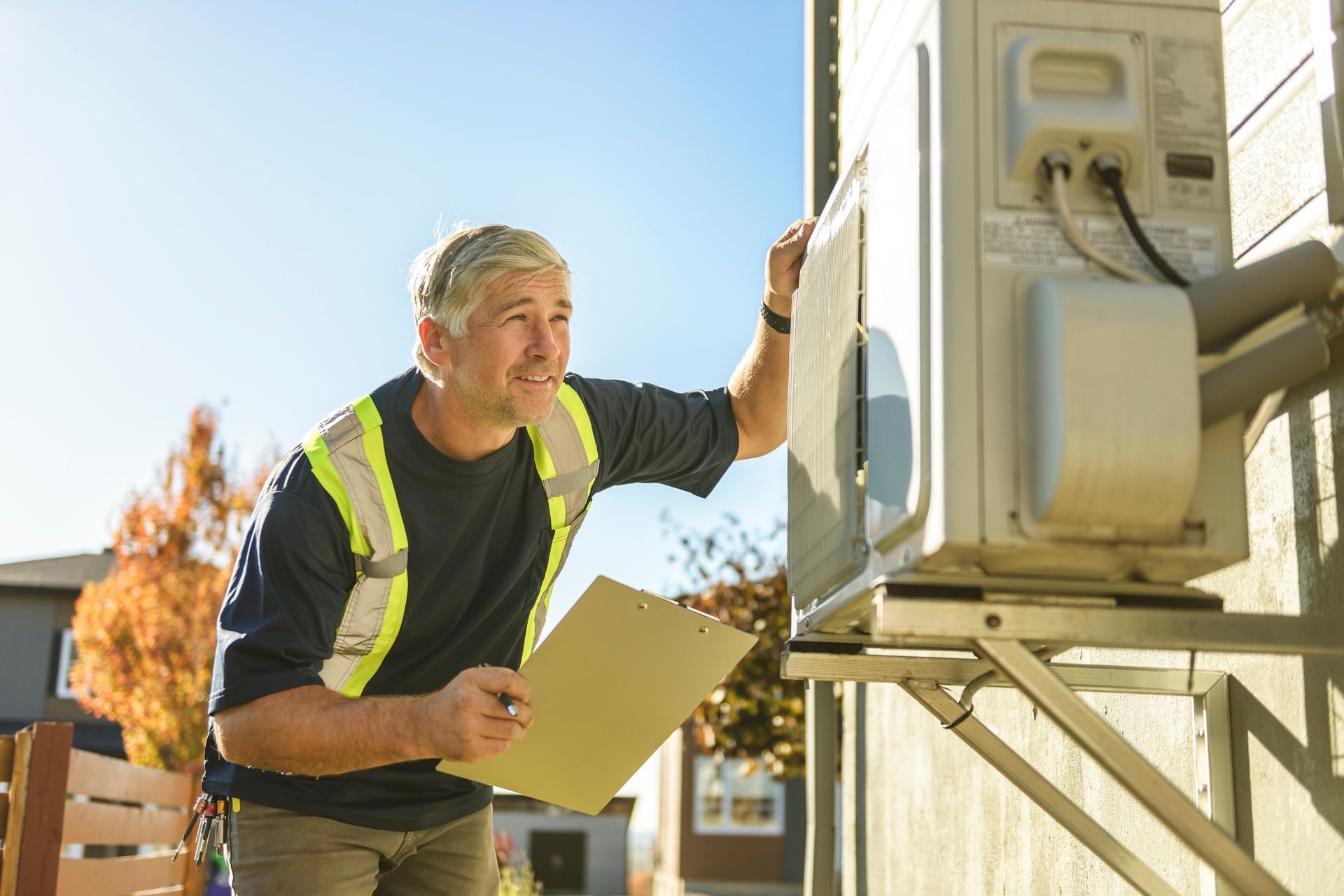 Technician servicing an outdoor air conditioning or heat pump unit. Technician servicing an outdoor air conditioning or heat pump unit.