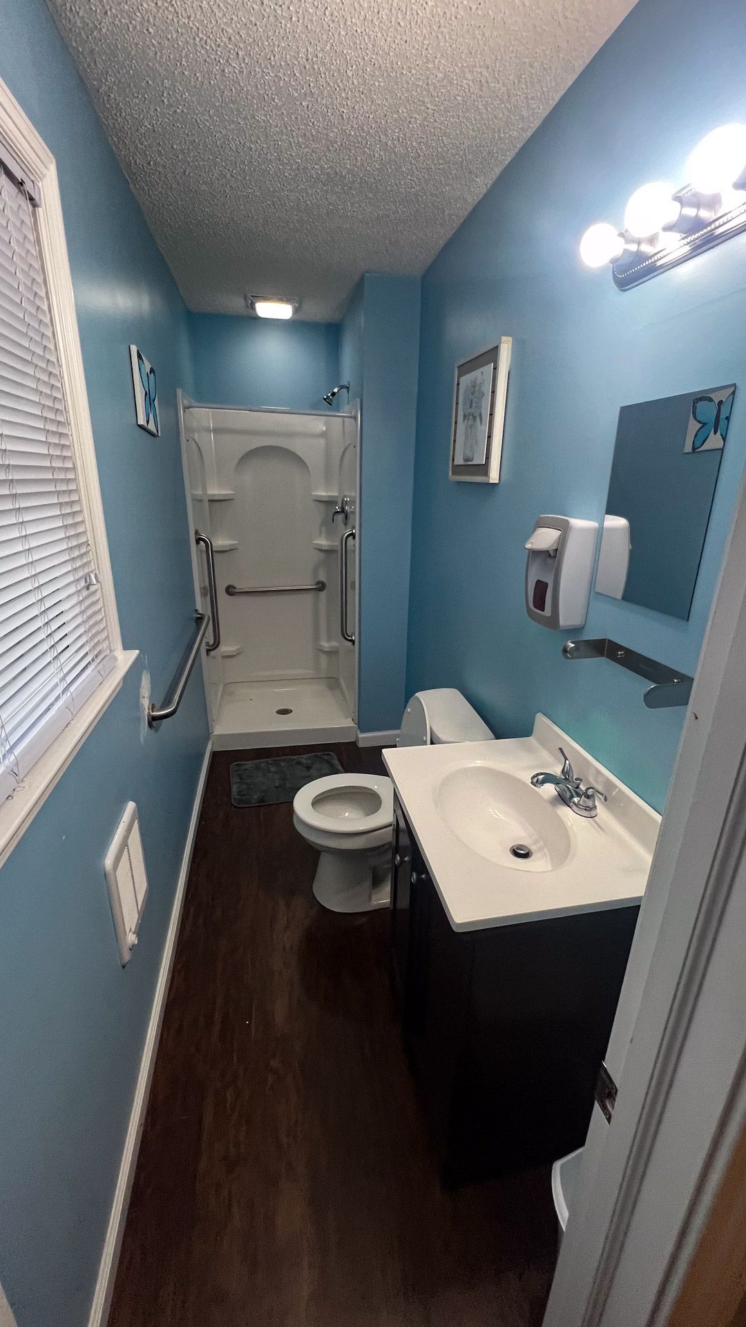 A bathroom with a toilet , sink , and shower.