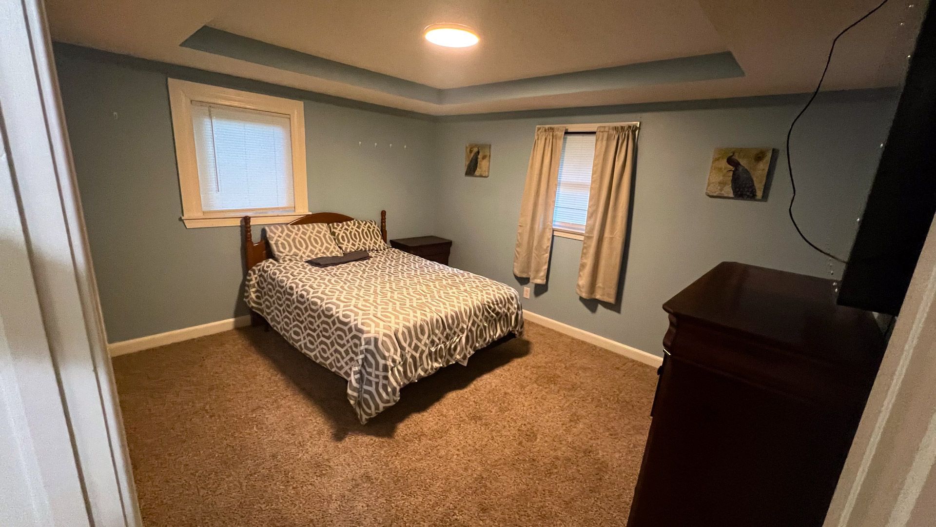 A bedroom with a bed , dresser , and television.