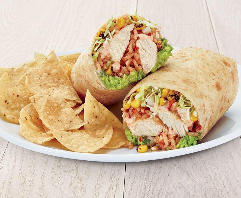 a tortilla wrap is on a plate with tortilla chips