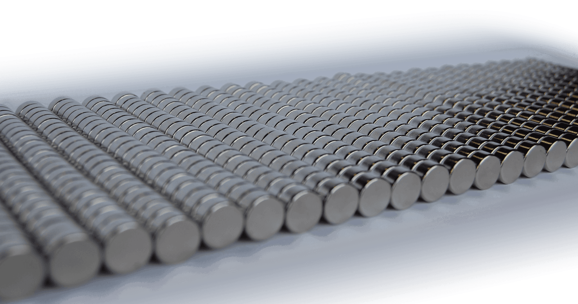 A row of metal rods stacked on top of each other on a white surface.