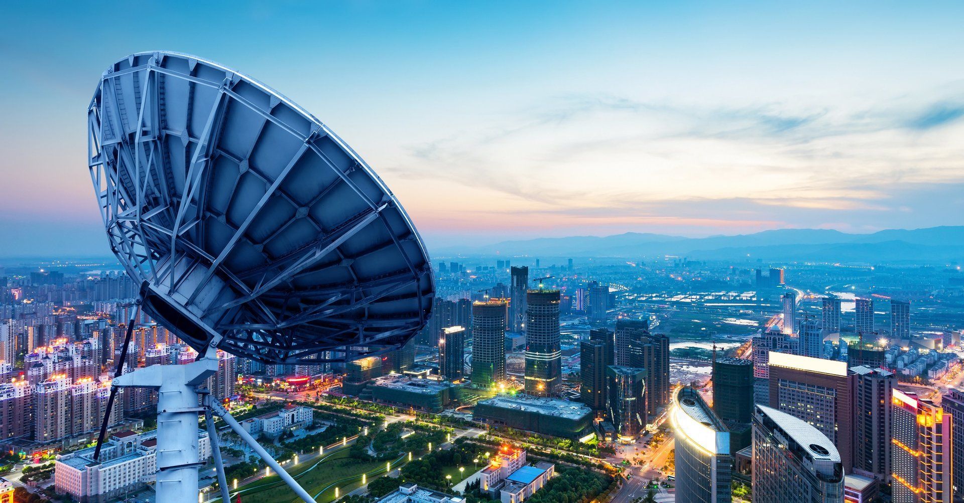 A large satellite dish is sitting in the middle of a city.