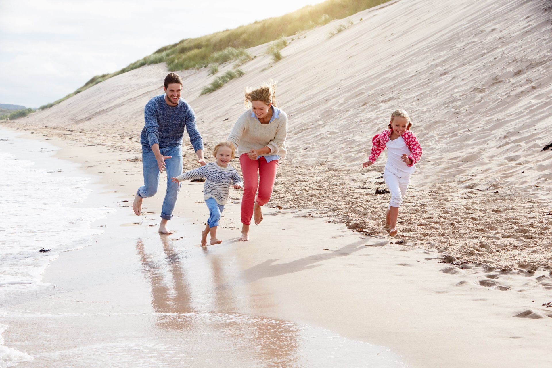 A family is running on the beach.