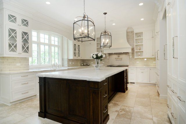 A kitchen with white cabinets and a large island