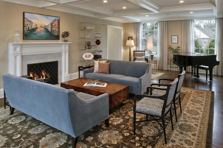 A living room with a fireplace , couch , chairs and a piano.
