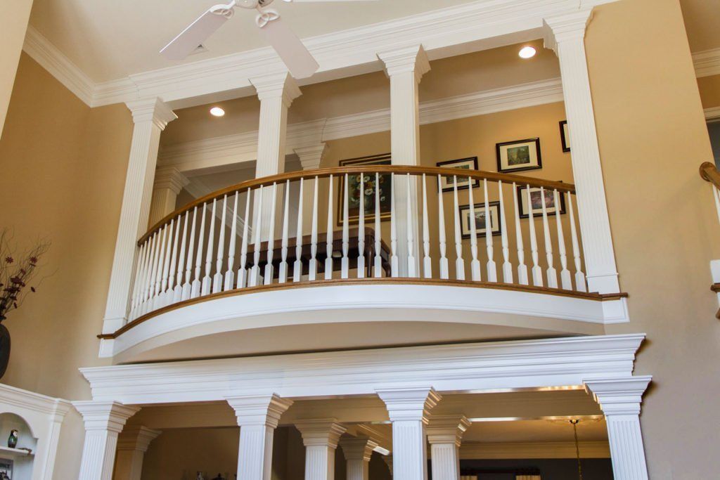 A large house with a balcony and a ceiling fan