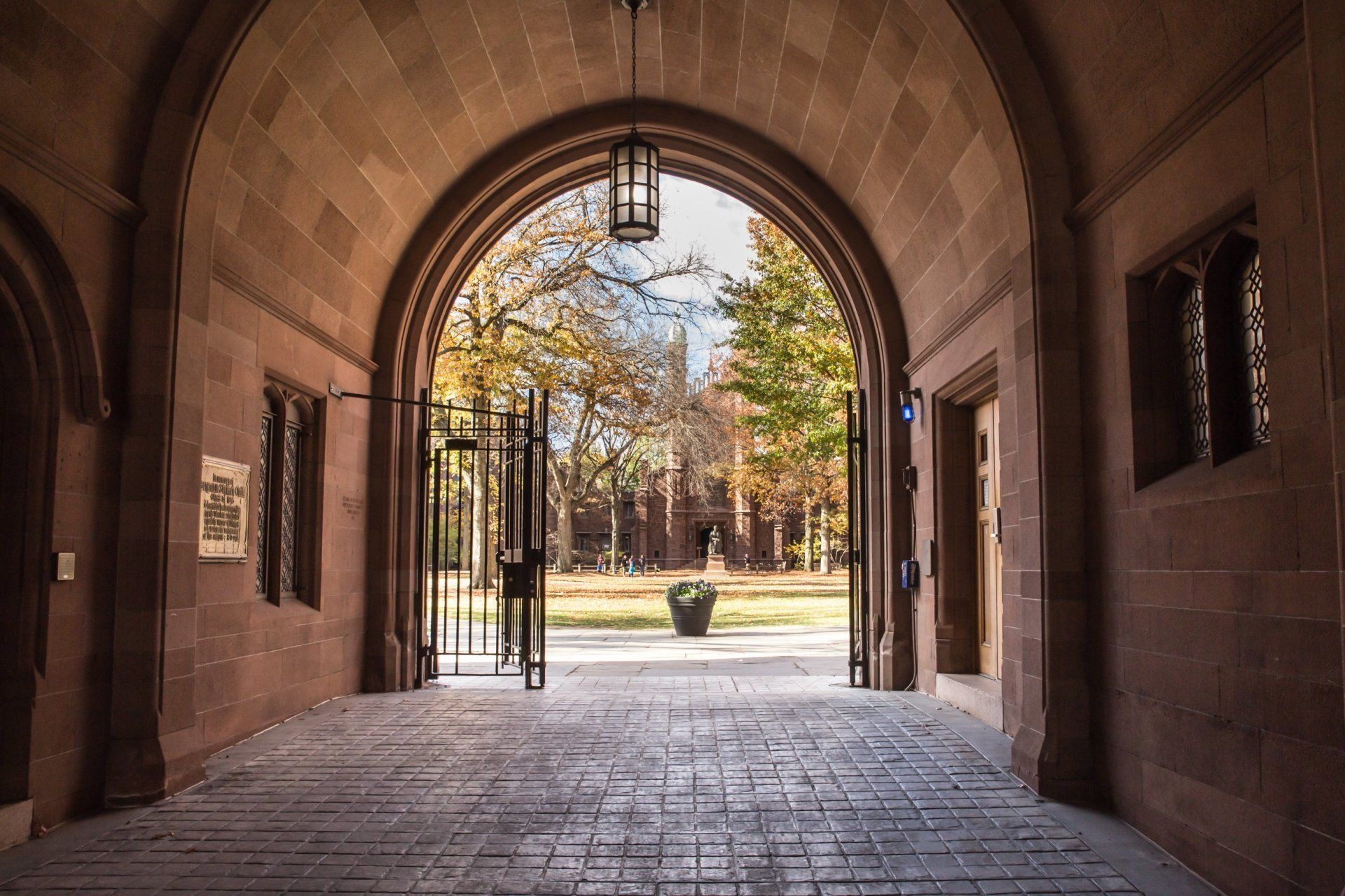 A stone archway leading to a park with trees in the background.