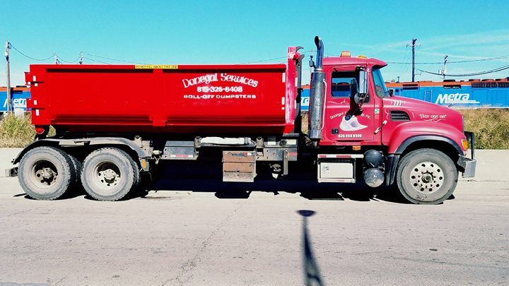 A red dump truck is parked in a parking lot.