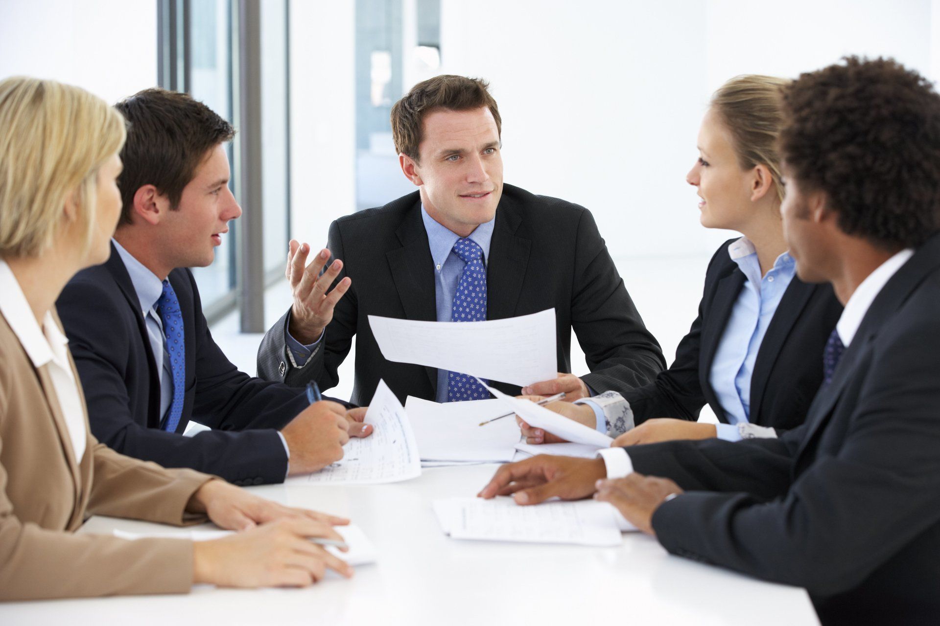 A group of business people are sitting around a table having a meeting