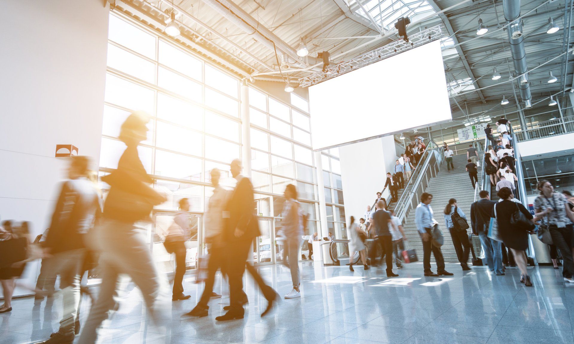 A large group of people are walking through a large building.