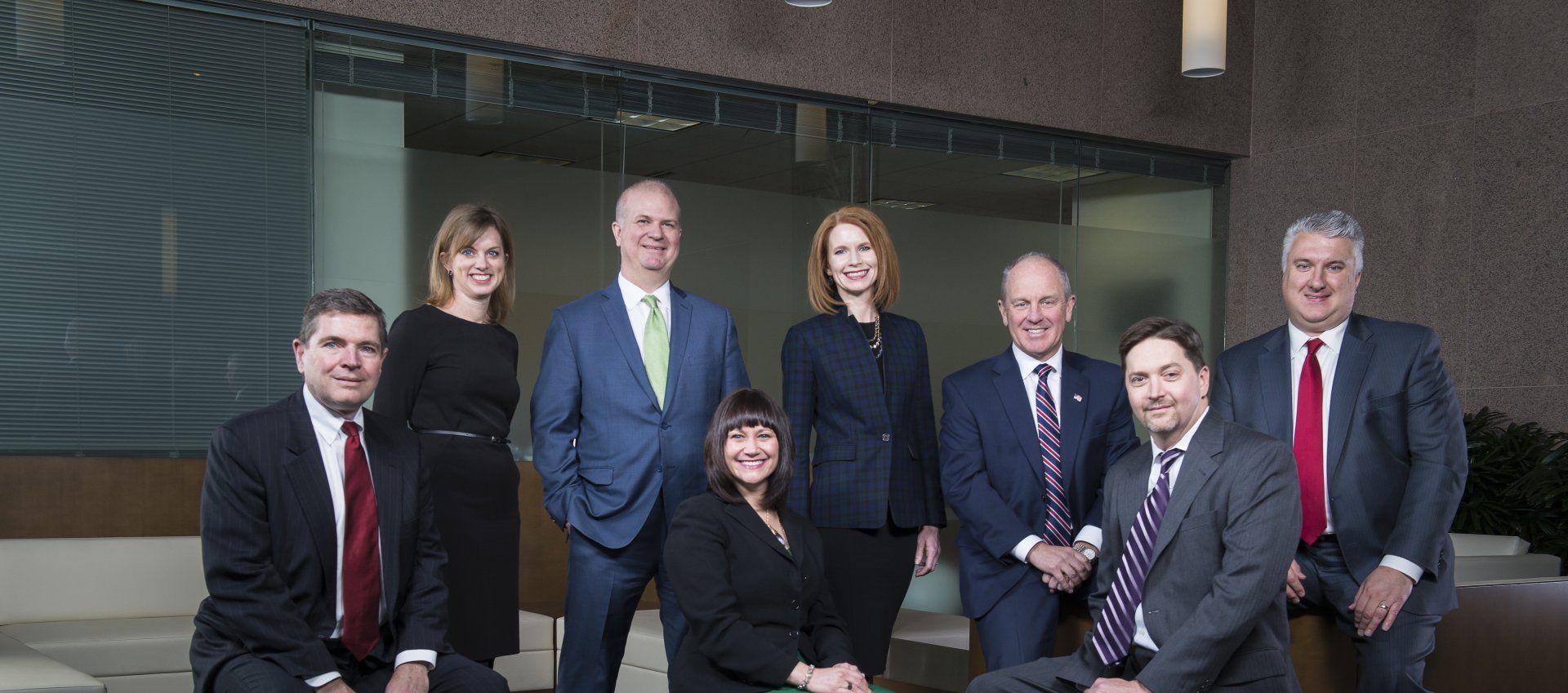 A group of people in suits and ties are posing for a picture.