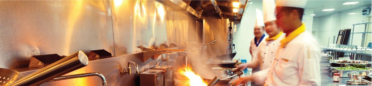 A group of chefs are cooking food in a kitchen.