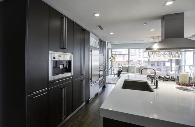 A kitchen with stainless steel appliances and black cabinets