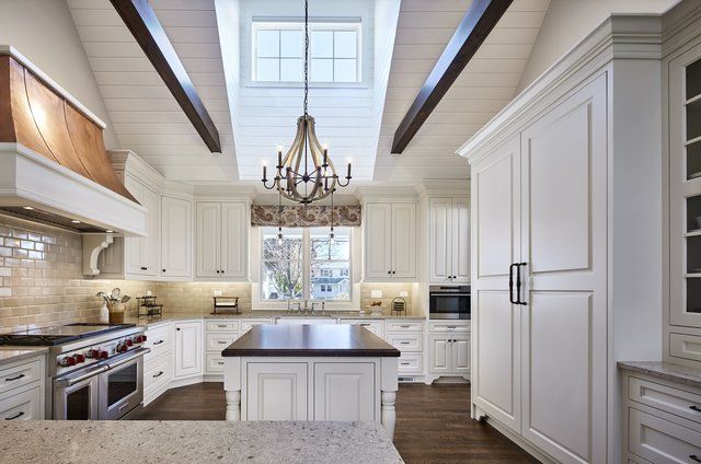 A kitchen with white cabinets and a large island