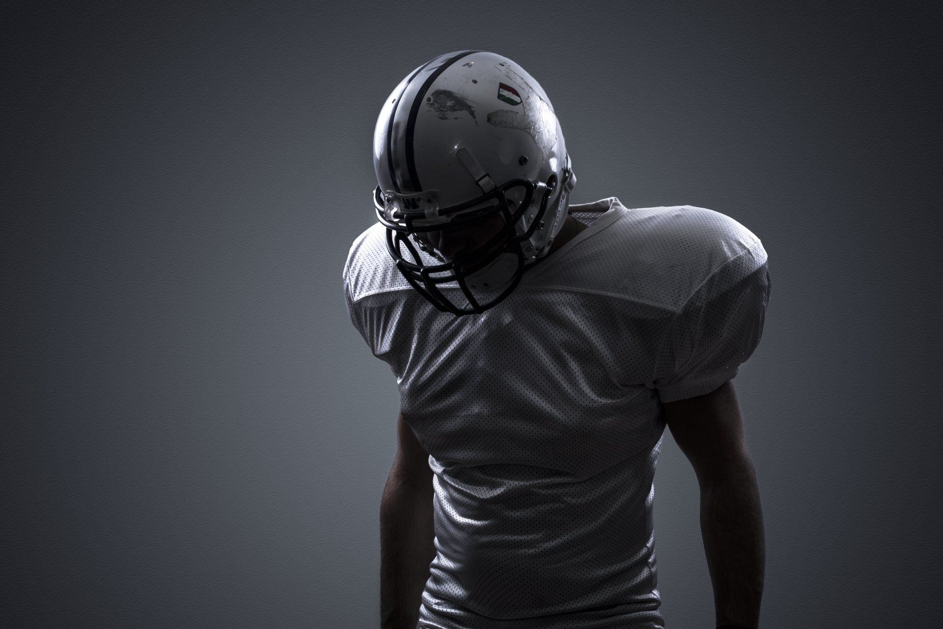 A football player wearing a helmet and a white jersey