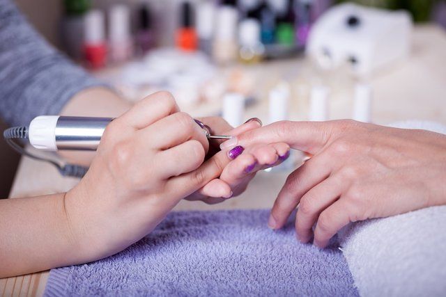 A woman is getting her nails done at a nail salon.