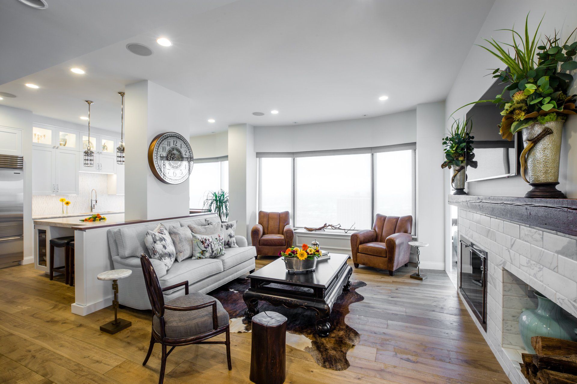A living room with a couch , chairs , coffee table and fireplace.