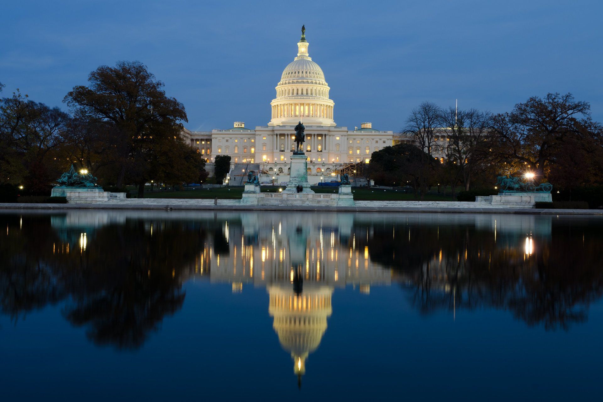 The capitol building is reflected in the water at night