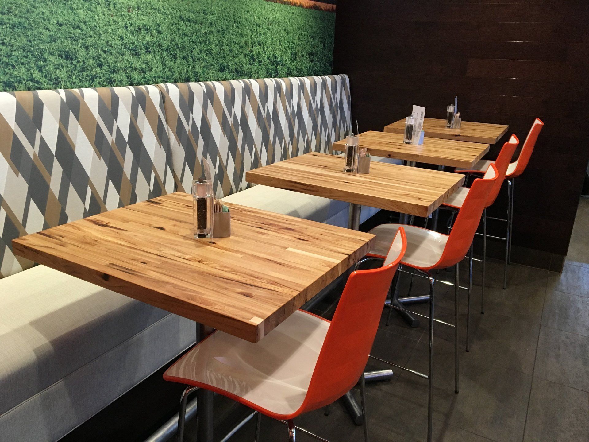 A row of wooden tables and chairs in a restaurant