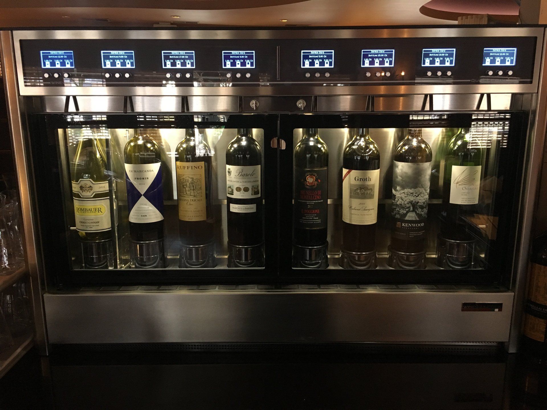 Several bottles of wine are lined up in a display case