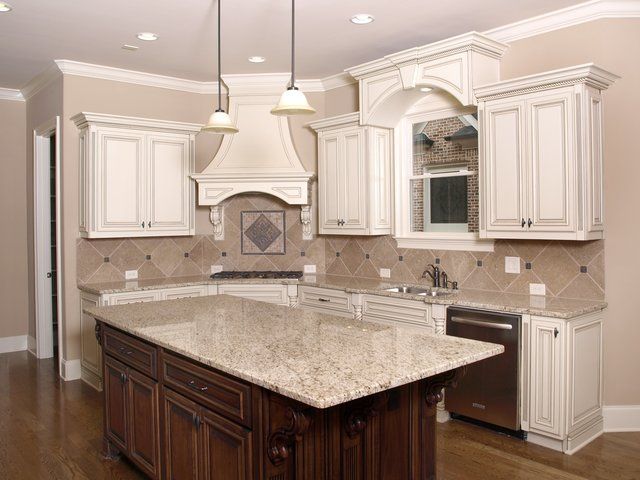 A kitchen with white cabinets and granite counter tops