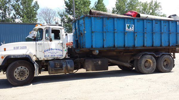 A blue dump truck is parked in a parking lot.