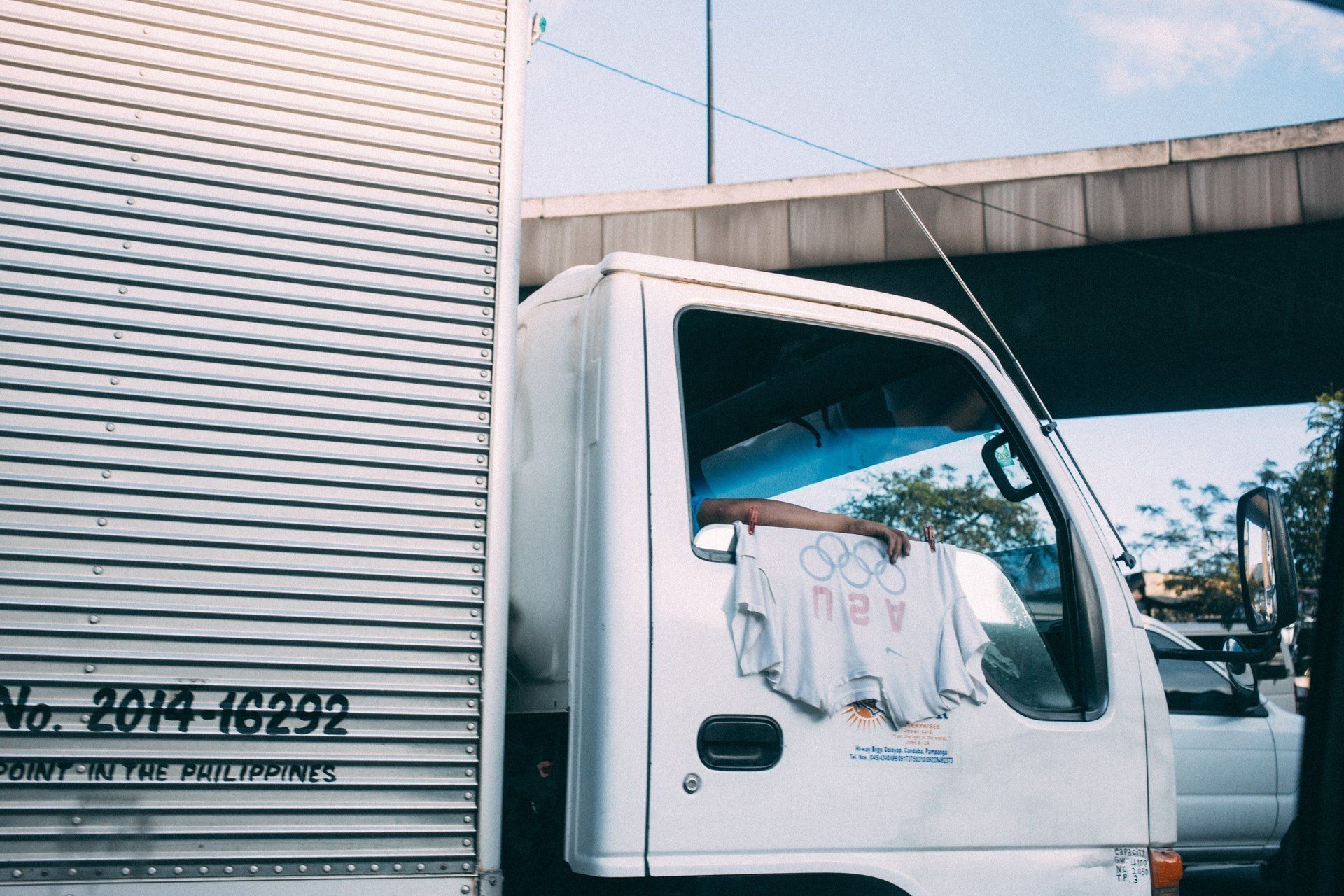 A man is sitting in the driver 's seat of a white truck.