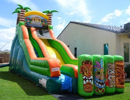 A large inflatable water slide is sitting in front of a house.
