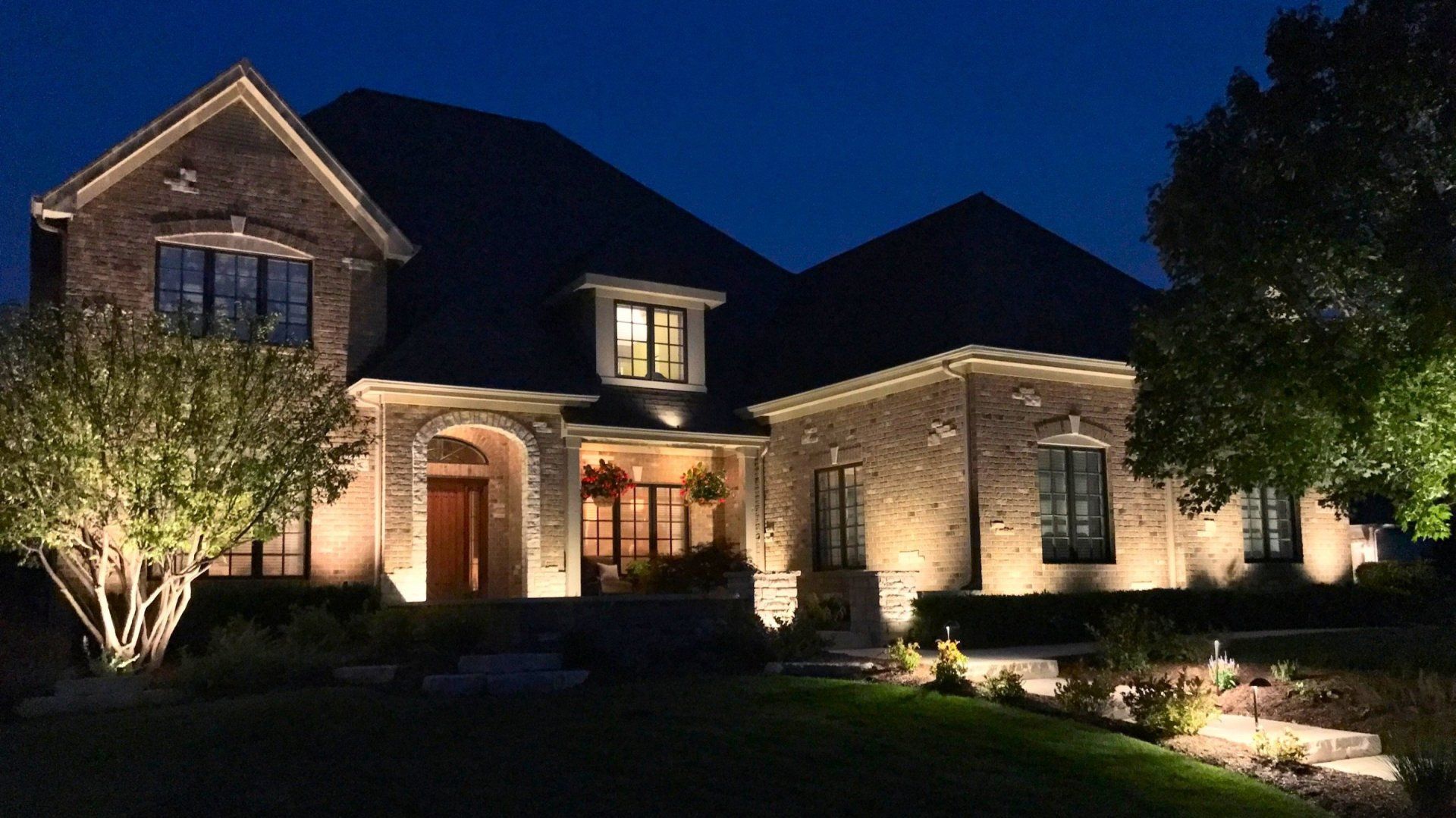 A large brick house is lit up at night.
