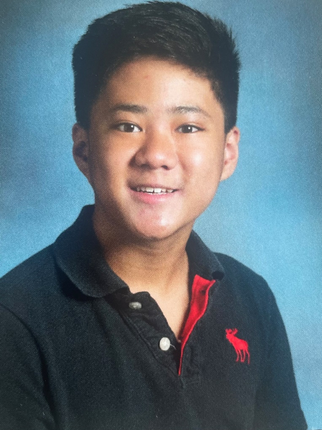 A young man wearing a black polo shirt with a red horse on it