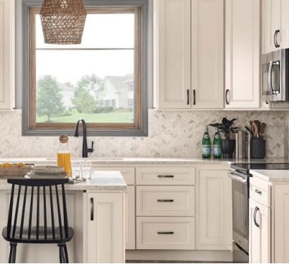 A kitchen with white cabinets , stainless steel appliances , a sink , and a window.