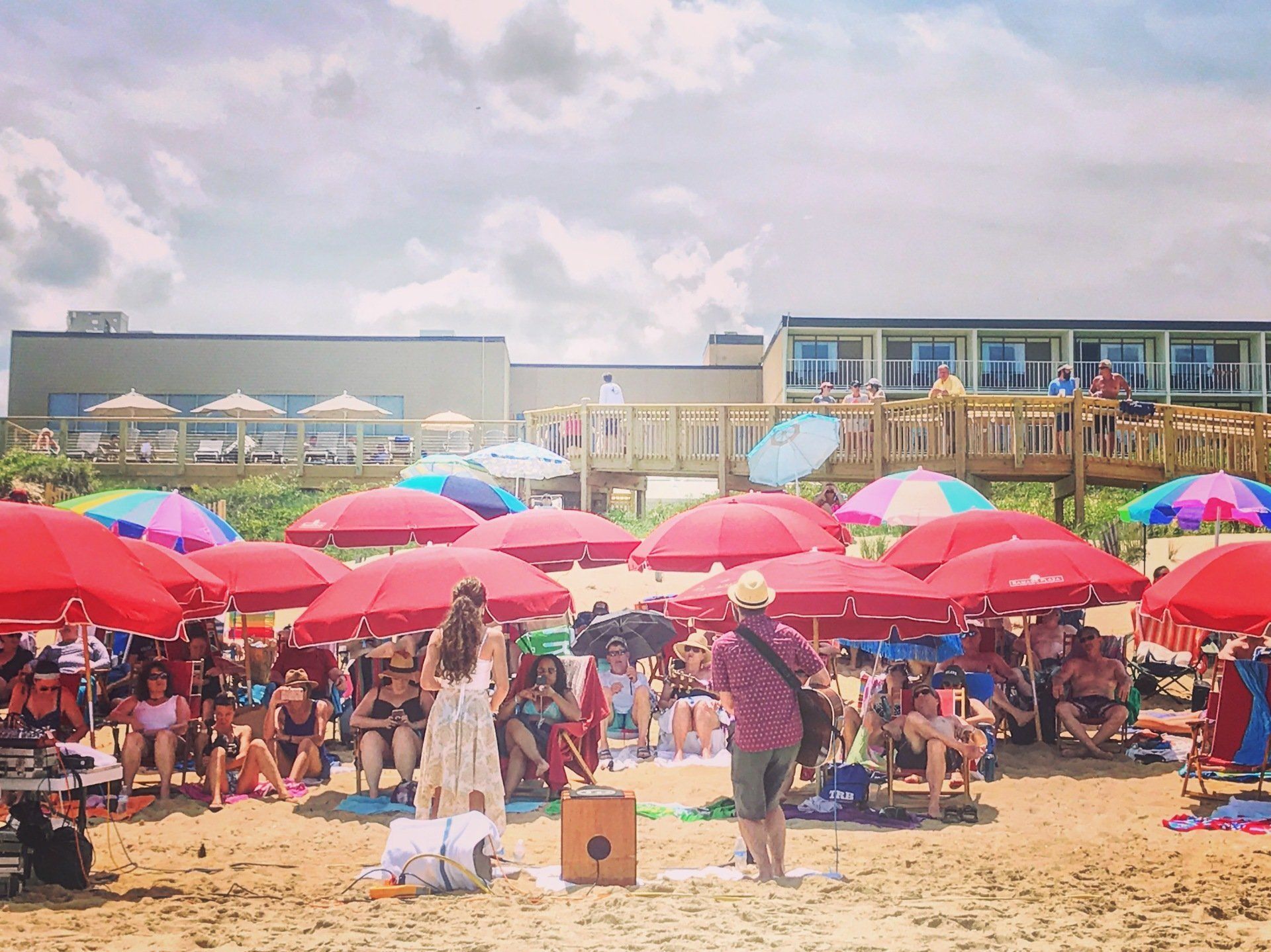 A group of people are sitting under umbrellas on a beach.