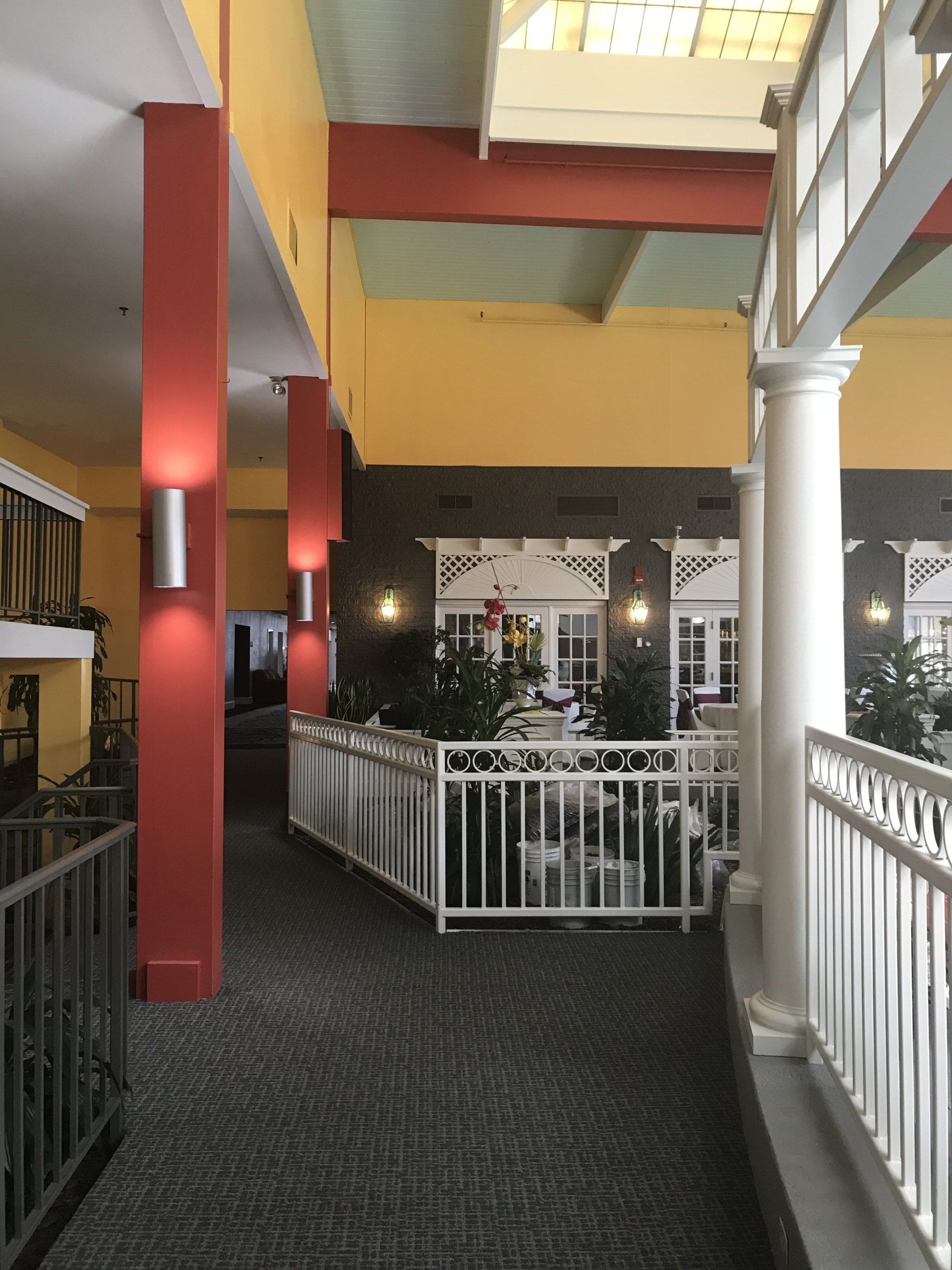 A hallway in a building with a white railing
