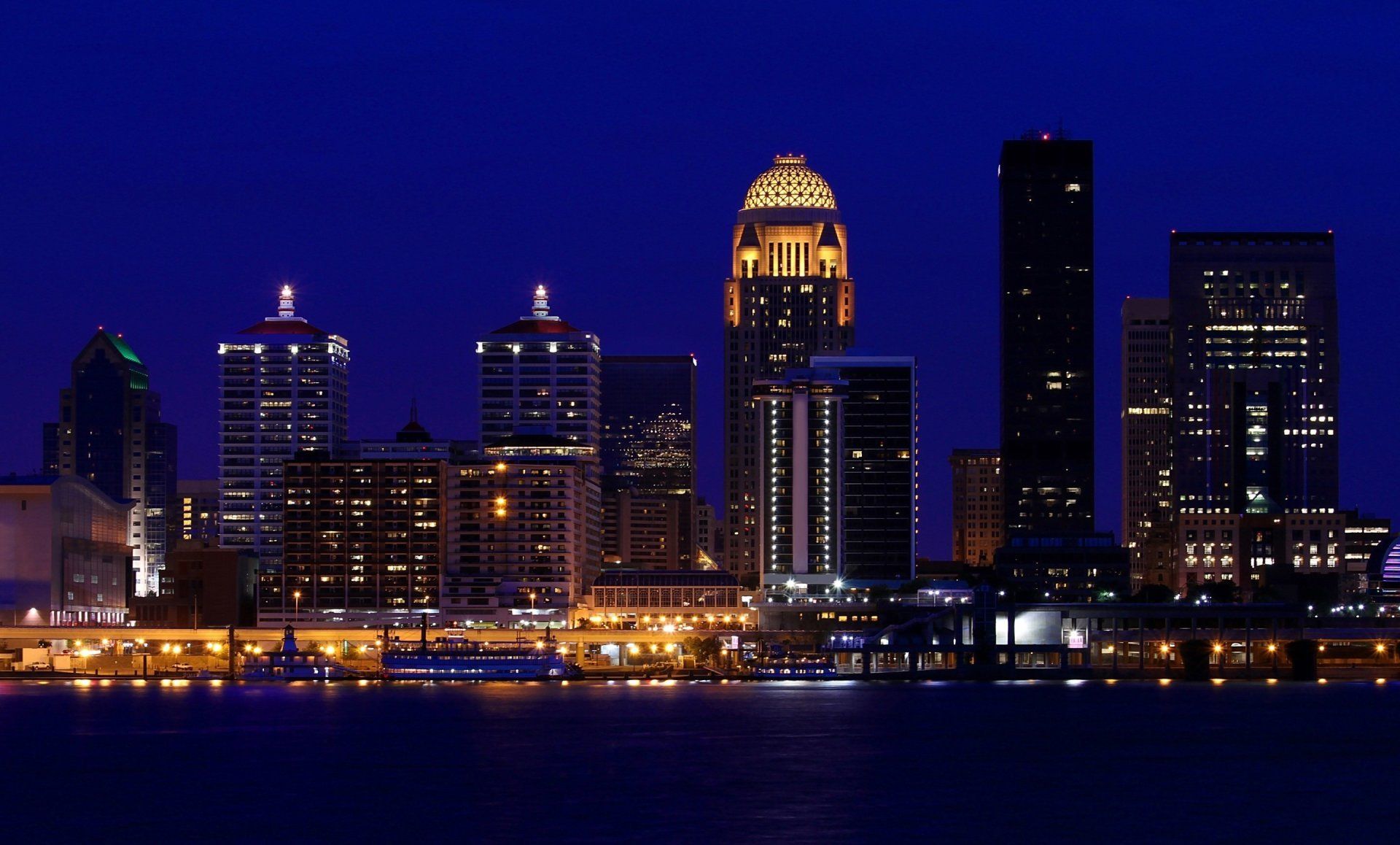 A city skyline at night with a few buildings lit up