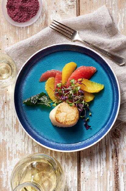 A blue plate topped with food and a fork on a wooden table.