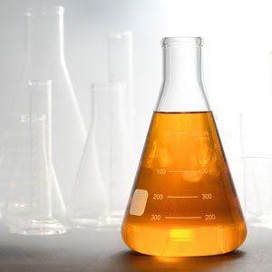 A beaker filled with orange liquid is sitting on a table.