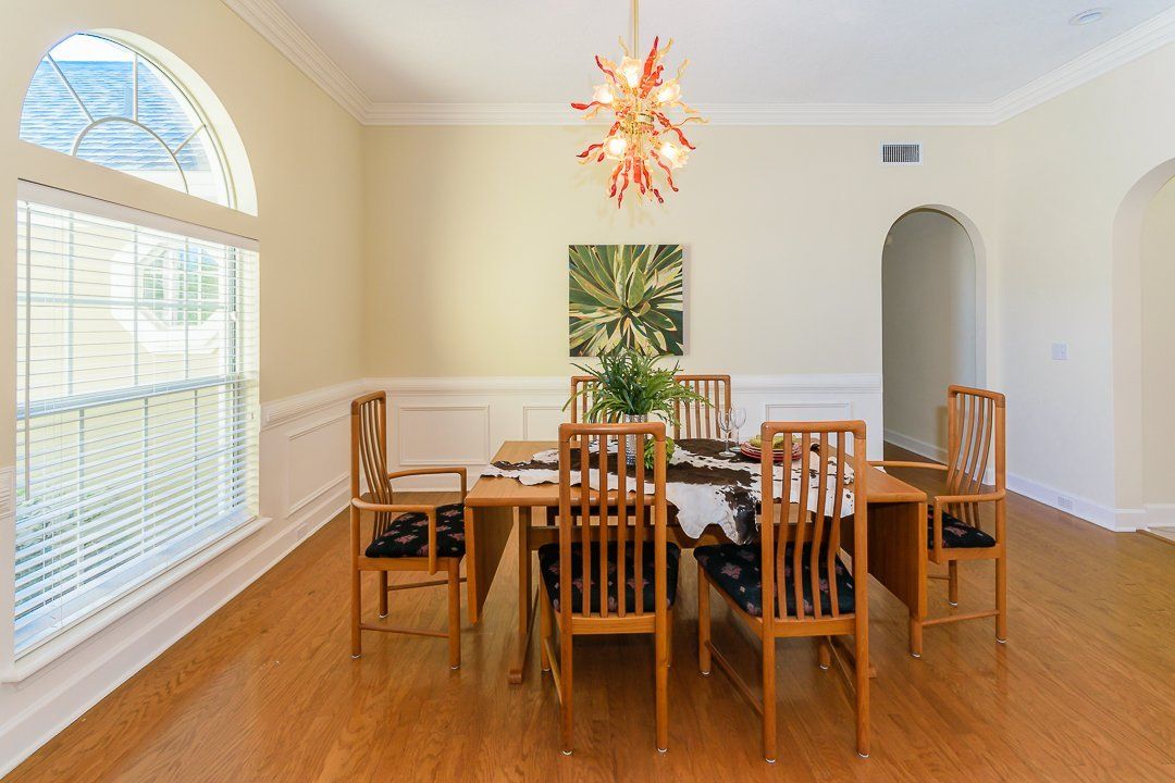 A dining room with a table and chairs and a chandelier.