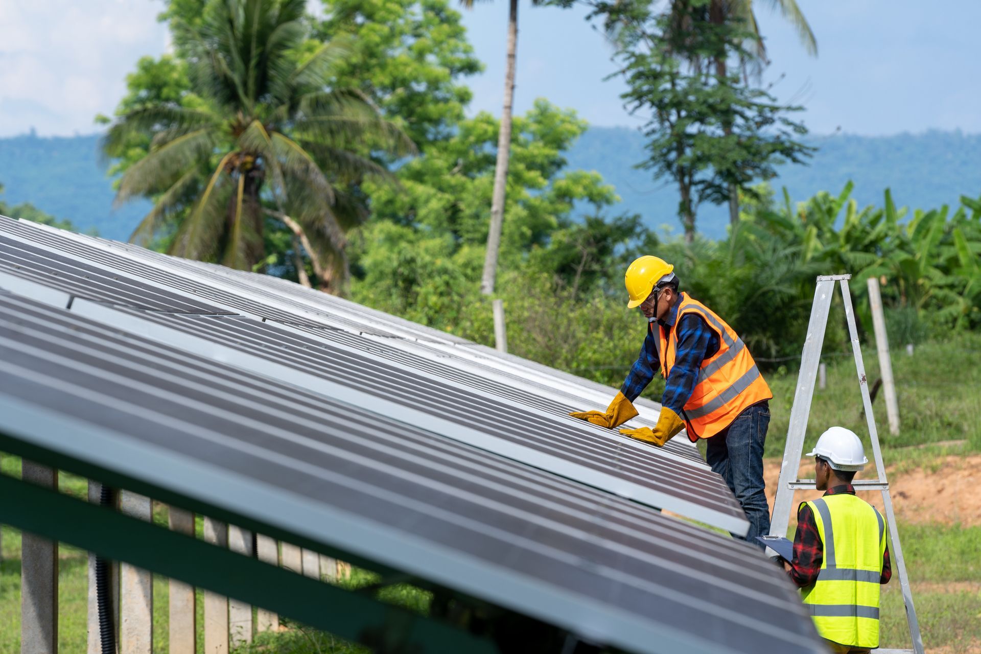 Technicians installing a metal roof, highlighting expert metal roofing supply service.