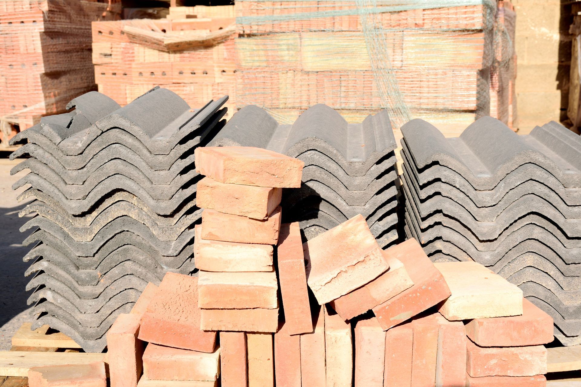 Piles of bricks and roof tiles sit under the sun. Piles of bricks and roof tiles sit under the sun.