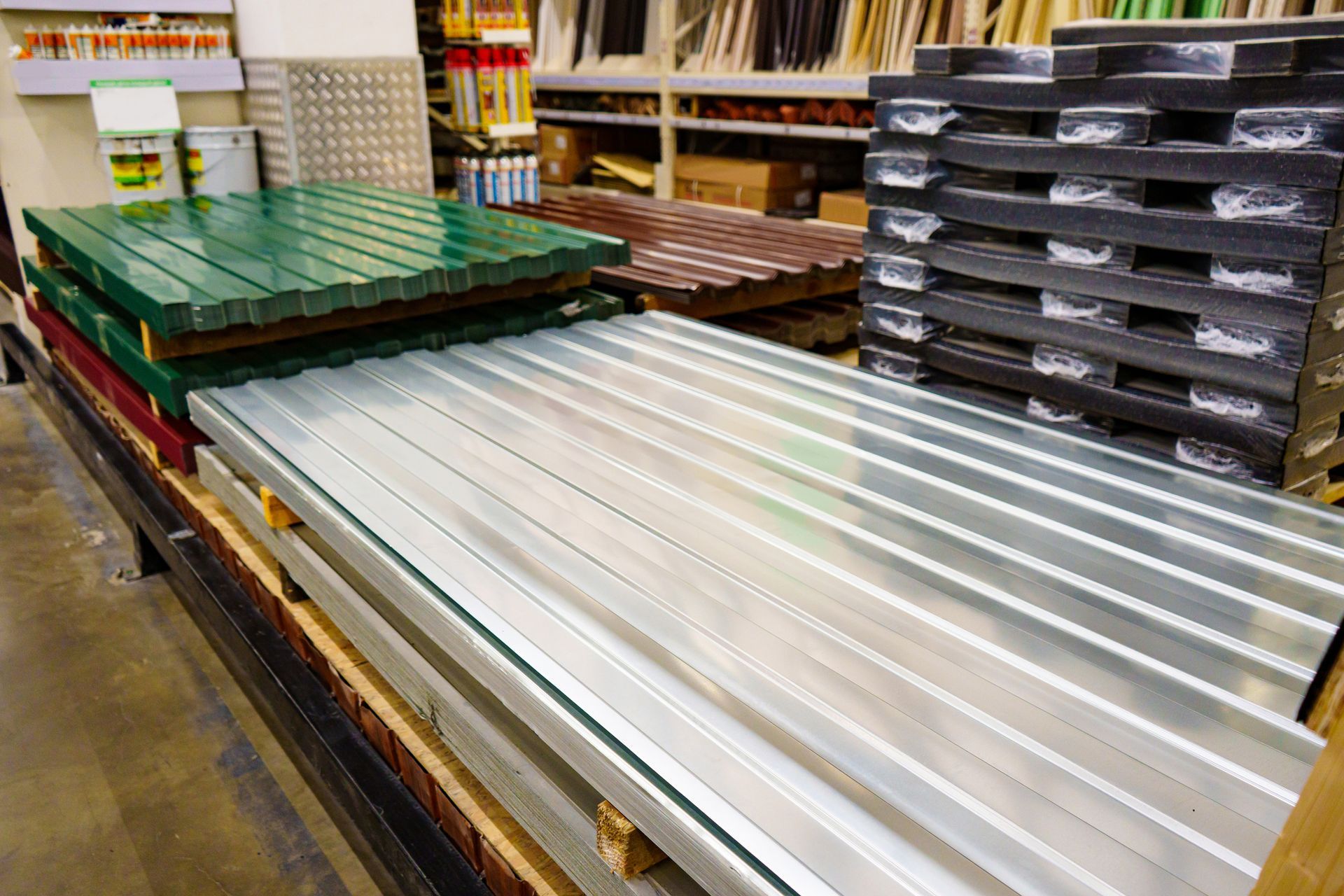 Stacks of colorful metal roofing sheets at a hardware store. 