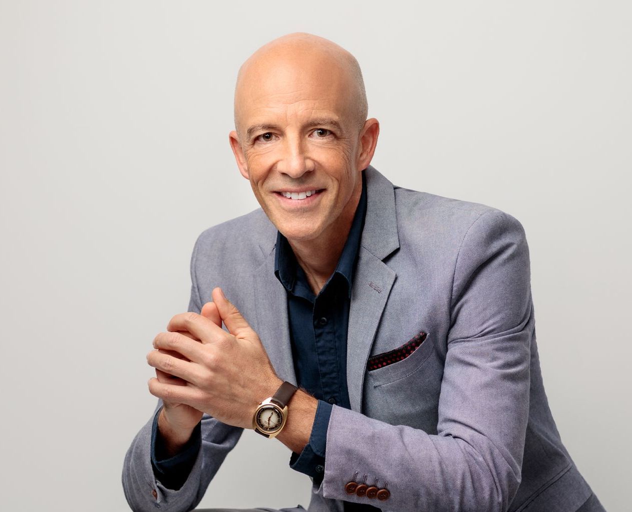 Michael Ceely, executive coach, in a grey blazer, smiling.