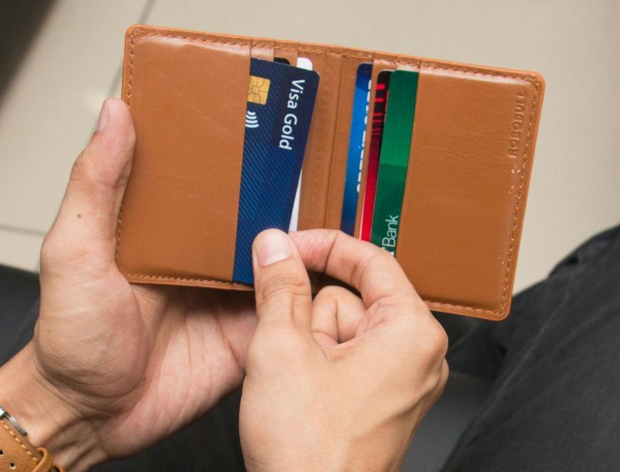 A man is holding a wallet with credit cards in it.