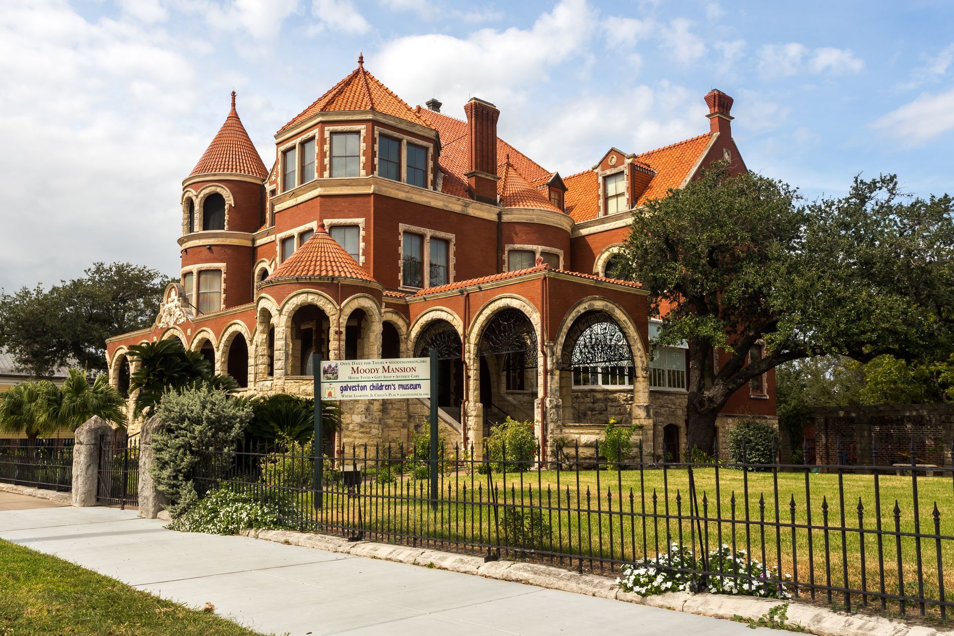 A large red brick building with a sign in front of it